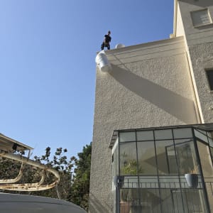 אדם על גג עם דוד שמש, רכב עבודה בחזית
