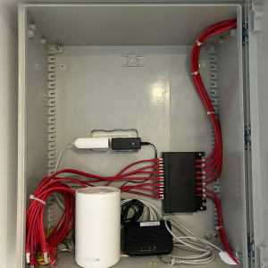 ארון תקשורת עם כבלים אדומים וציוד רשת