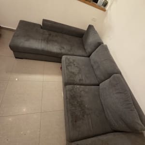 ספה אפורה עם כתמים על הרצפה