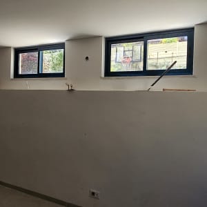 חלונות אלומיניום עם מסגרות כחולות בקיר לבן