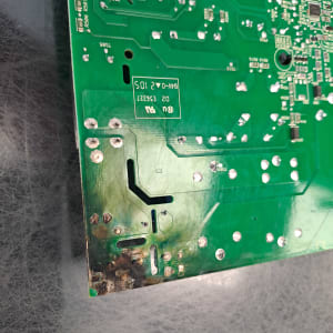 מעגל מודפס ירוק עם סימני שריפה בפינה התחתונה