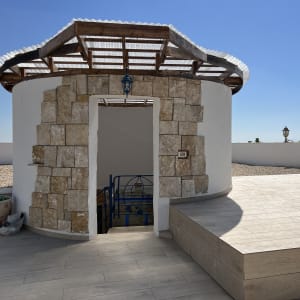 מבנה עגול עם גג עץ ומדרגות חיצוניות