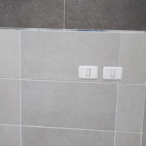 שני מתגים על קיר אריחים אפור