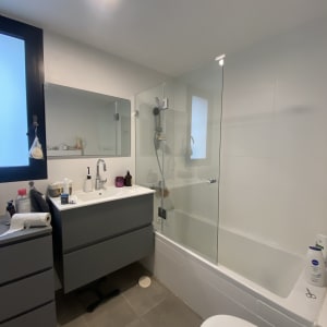 מקלחת עם דלת זכוכית, ראש מקלחת ומוצרי טיפוח