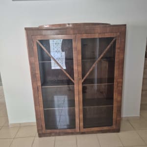 ארון עץ עם דלתות זכוכית על רצפת אריחים