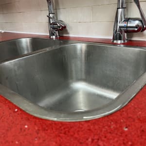 כיור כפול עם ברזים על משטח אדום