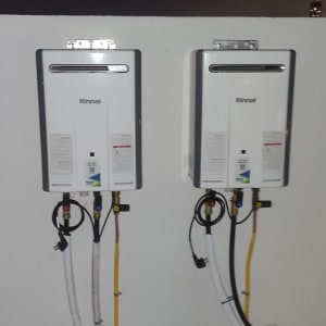 שני מחממי מים מותקנים על קיר עם צינורות חיבור