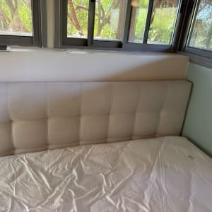 מיטה עם ראש מיטה מרופד ליד חלון