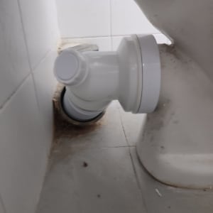 חיבור צינור לבן לאסלה על רצפת אריחים