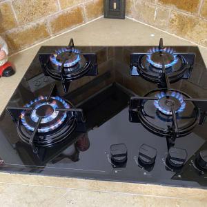 כיריים גז שחורות עם ארבעה מבערים דולקים