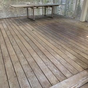 רצפת עץ עם שולחן עץ במרפסת מגודרת