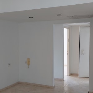 קיר לבן עם מסגרת עץ ומברשת צביעה