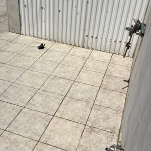 רצפה מרוצפת עם ברז וקיר מתכת