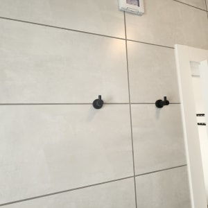 שני ווים שחורים מותקנים על קיר אריחים