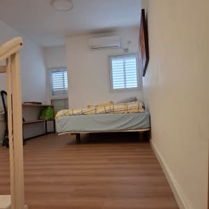 רצפת פרקט בחדר שינה עם מיטה ומזגן