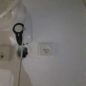 שקע חשמלי על קיר לבן עם חוטים חשופים