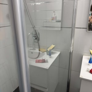 מקלחת עם כיור ומוצרים לניקוי