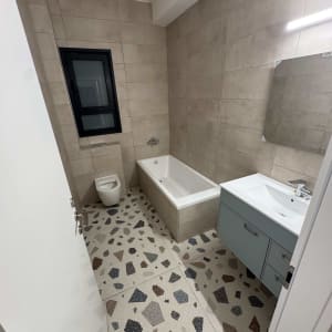 חדר אמבטיה עם אמבטיה, כיור ושירותים