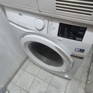 מכונת כביסה AEG בחדר כביסה עם רצפה רטובה