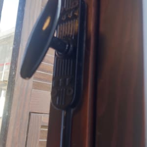 ידית חלון מתכתית על מסגרת עץ