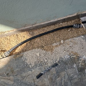 צינור מונח על רצפה עם חצץ, עבודה בתחום האינסטלציה