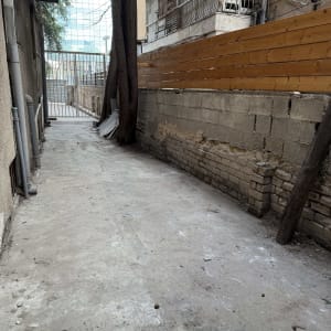 גדר עץ לאורך שביל בטון ליד בניין