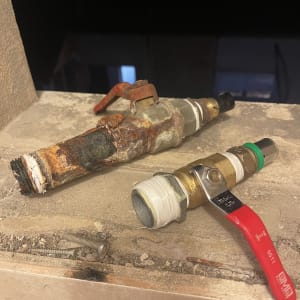 שני ברזים ישנים וחלודים על משטח בטון