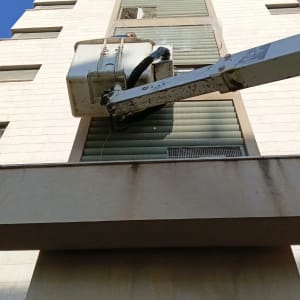 מנוף ליד בניין גבוה עם תריסים