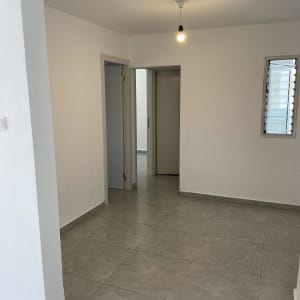 חדר ריק עם רצפת אריחים ונורה תלויה