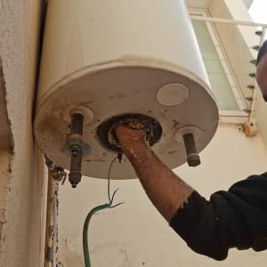 דוד שמש מותקן על קיר עם יד מתקין