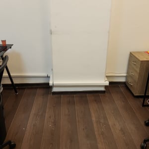 רצפת עץ כהה עם קיר לבן ורהיטים