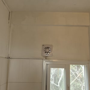 קיר עם סימני רטיבות ליד חלון מאוורר