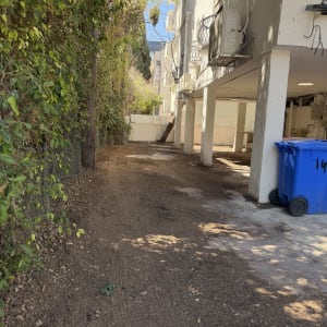 שטח אדמה עם צמחייה ליד בניין מגורים