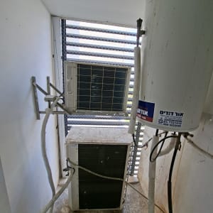 מערכת מיזוג אוויר ומיכל מים בחדר קטן