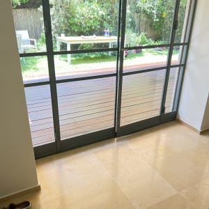 מרפסת עם דלת זכוכית ונוף לגינה ירוקה
