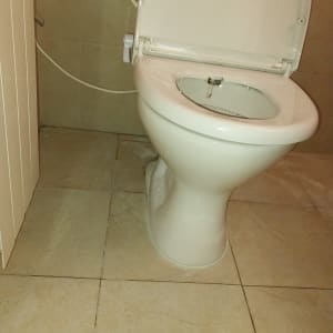 אסלה לבנה בחדר אמבטיה עם מדבקה ירוקה