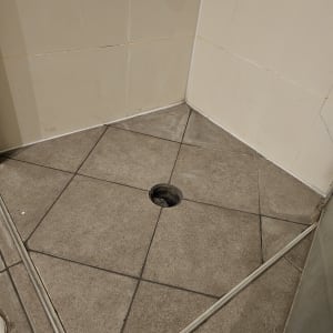 ריצוף אריחים עם חור לניקוז במקלחת