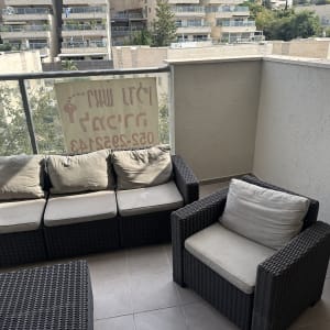 פינת ישיבה מראטן במרפסת דירה עם קירות צבועים