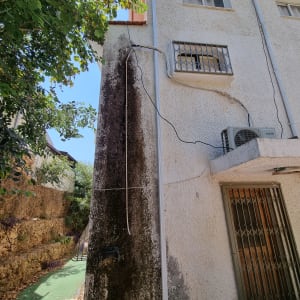 גג עם רעפים חומים וצינור ניקוז לבן