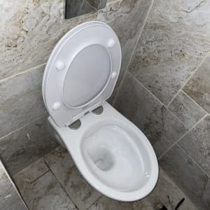 אסלה לבנה מותקנת בחדר אמבטיה עם אריחים