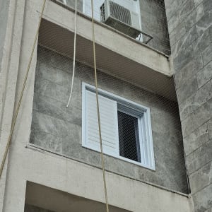 רשת יונים מותקנת על חלון בניין למניעת כניסת יונים