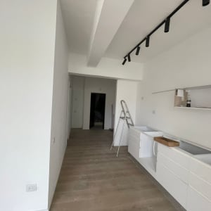 קיר גבס לבן עם מדפים ומטבח בהתקנה