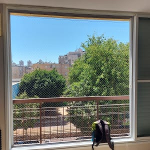 רשת מתכת על חלון למניעת כניסת יונים