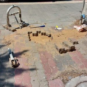 עבודת ריצוף עם כלים ובלוקים על מדרכה