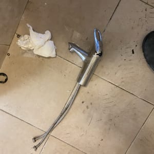 ברז מונח על רצפה עם צינורות מחוברים