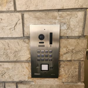 פאנל כניסה עם מצלמה ומקשים על קיר אבן