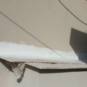 איטום לבן על גג מתכת עם קיר לבנים