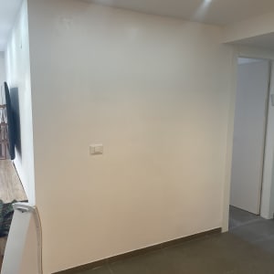 קיר צבוע בלבן עם תאורה עליונה