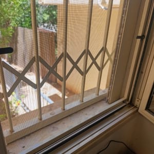 חלון עם סורגי אלומיניום ונוף חיצוני