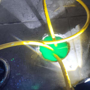 צינור צהוב עם נוזל ירוק במשטח רטוב